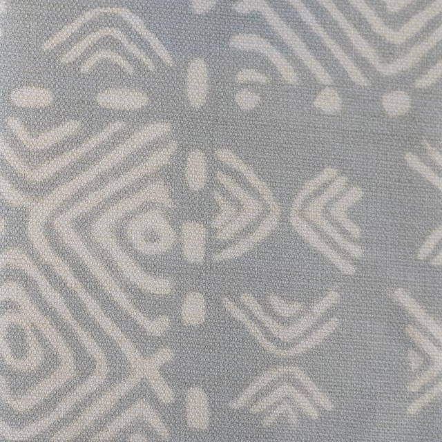Soft grey woven fabric with pale geometric African-inspired motifs