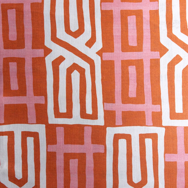 Coral orange geometric fabric swatch with white and blush pink motifs