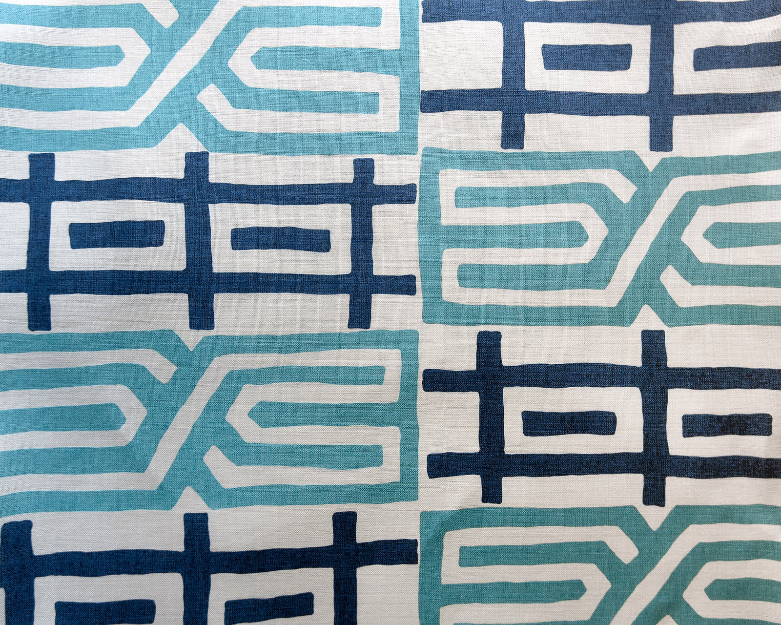 Large navy and aqua geometric fabric on a pale woven ground