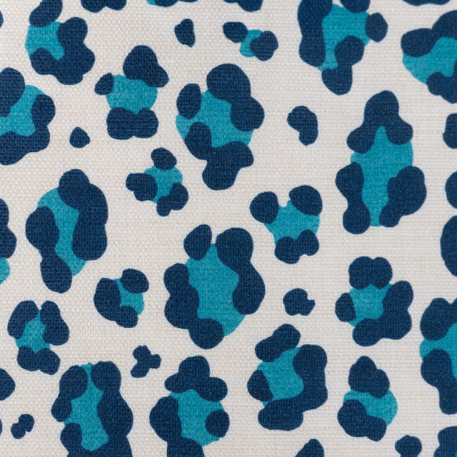 Small teal and navy leopard spots on a pale cream woven fabric
