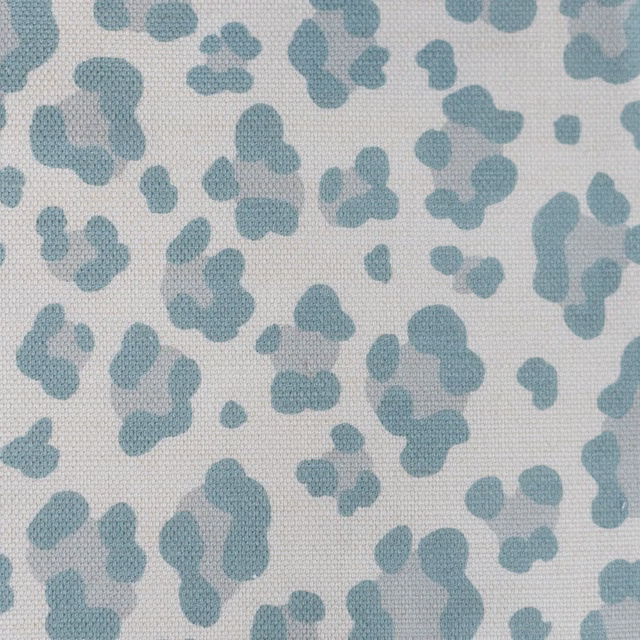 Small aqua leopard spots scattered over a light woven off-white fabric