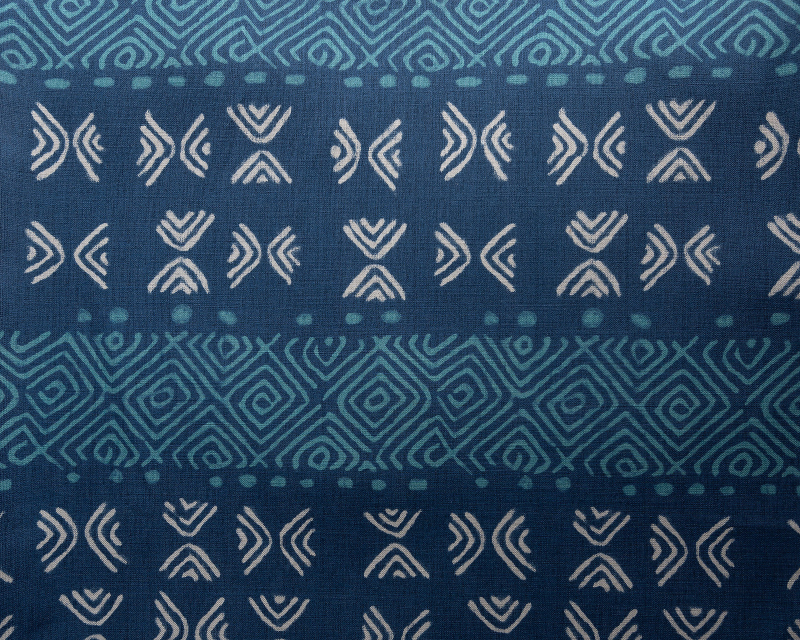 Deep indigo fabric with teal geometric stripes and ivory tribal motifs
