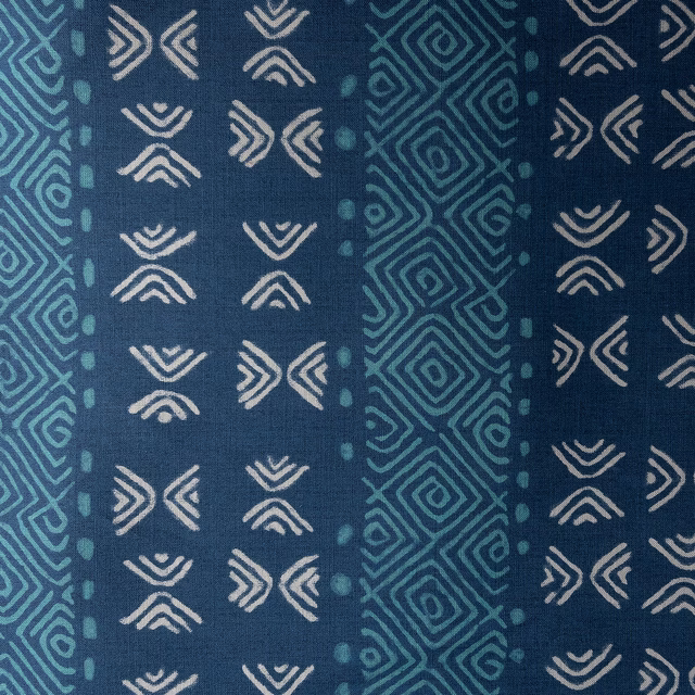 Deep indigo fabric with teal geometric stripes and ivory tribal motifs