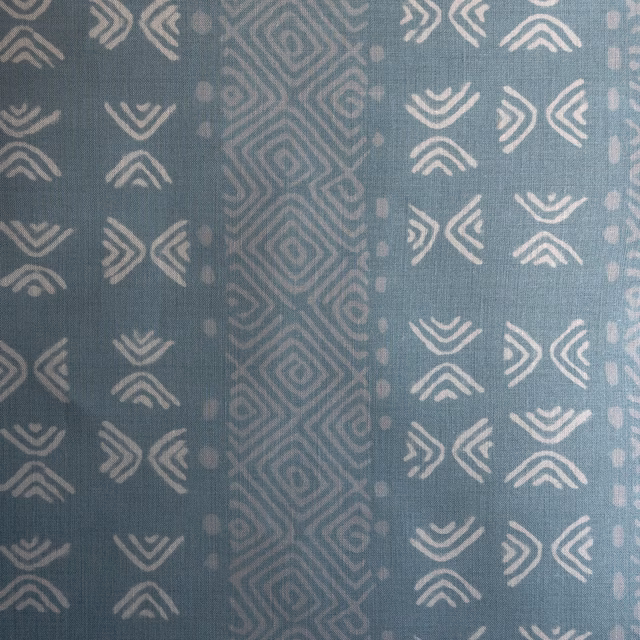 Blue-green geometric fabric swatch with pale chevrons and diamond stripes