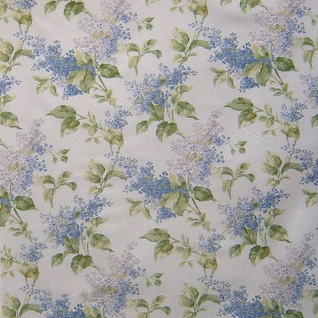 Pale linen-look floral fabric with blue lilacs and green leaves