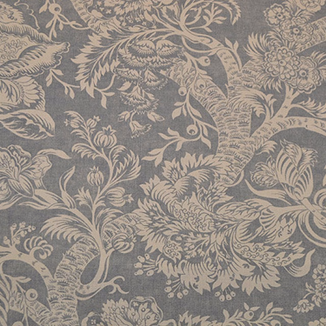 Large-scale tree and foliage fabric in soft slate grey with pale botanical motifs