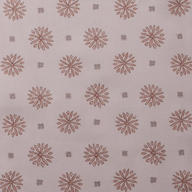 Soft blush pink printed fabric with spaced floral rosettes and tiny motif dots