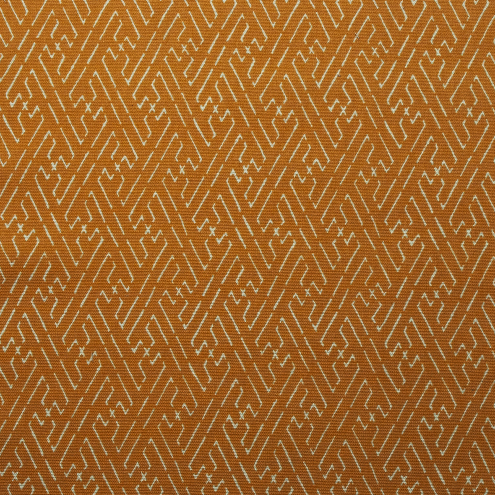 Amber orange cotton fabric with a small pale geometric trellis pattern