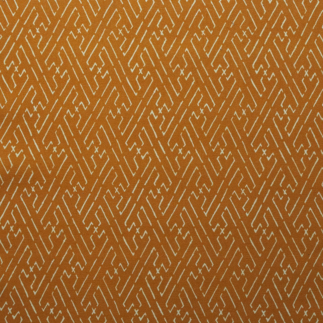 Amber orange cotton fabric with a small pale geometric trellis pattern