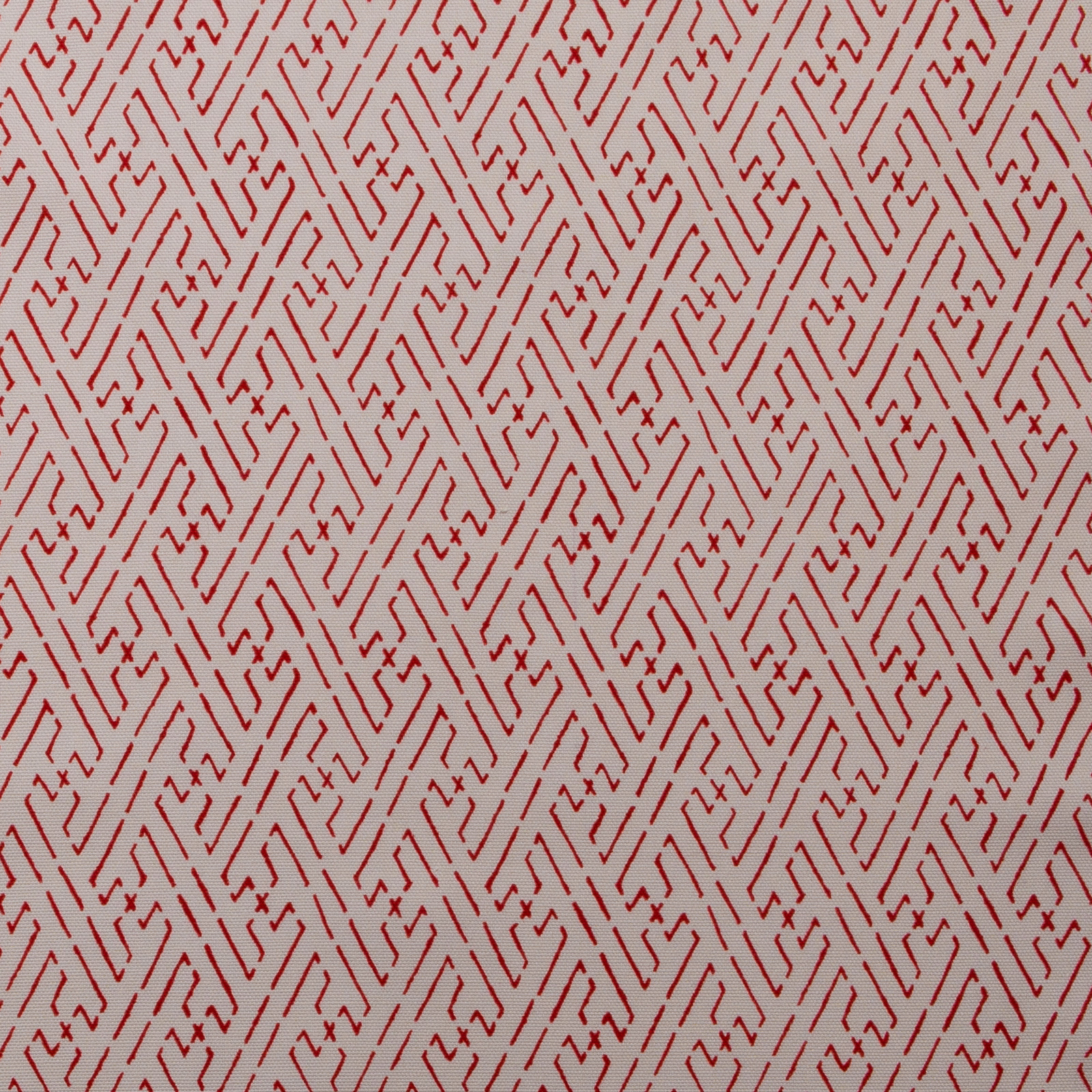 Red geometric trellis print on a pale cream fabric ground