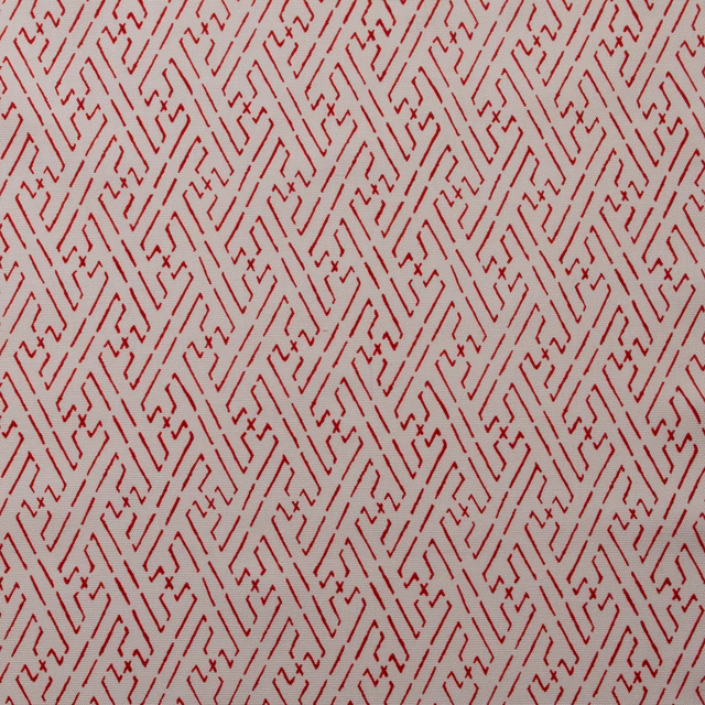 Red geometric trellis print on a pale cream fabric ground
