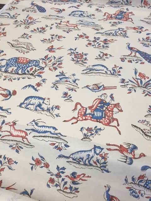 Ivory printed fabric with red and blue safari animals and riders