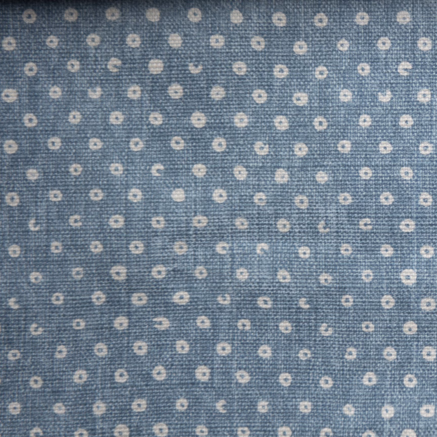 Blue woven fabric with tiny ivory ring spots on a textured ground