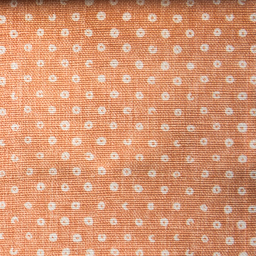 Paprika orange woven fabric with small white dot pattern
