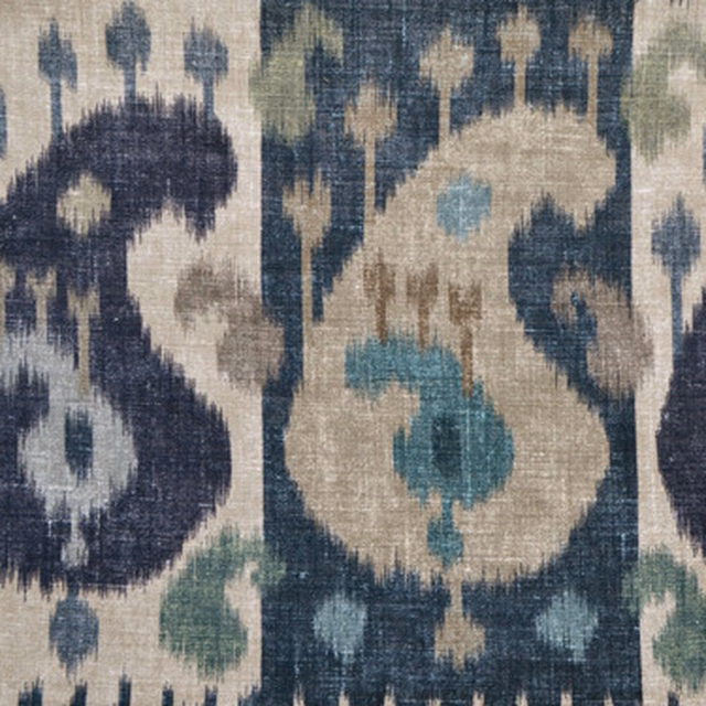 Close-up of indigo and sapphire ikat boteh motifs on a pale woven ground