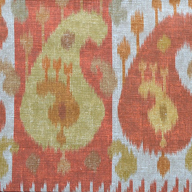 Close-up of paprika red and ochre ikat boteh fabric with cream ground
