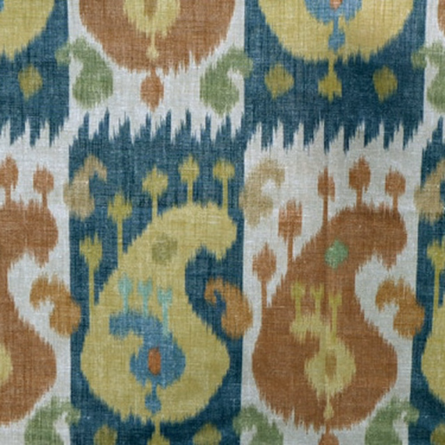 Close-up swatch of ikat boteh fabric in terracotta, turquoise and sage on a pale ground
