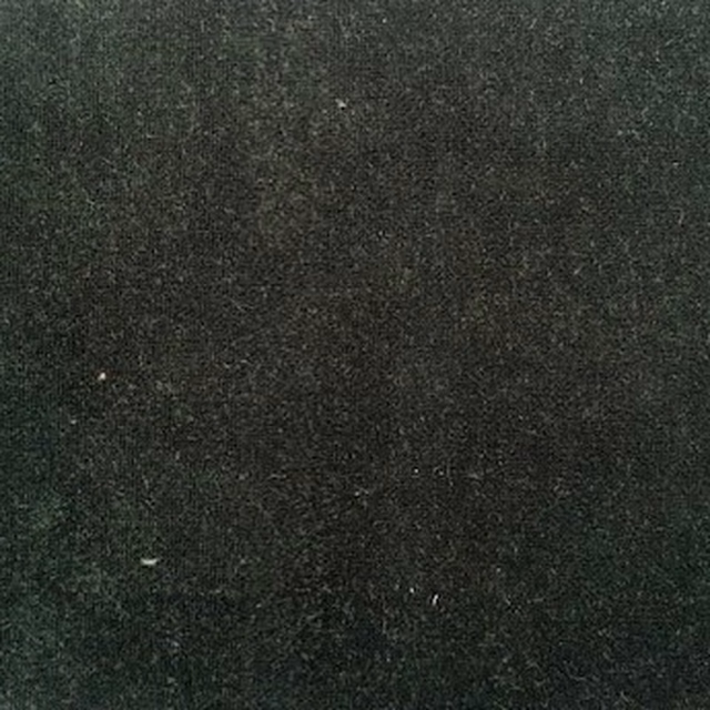 Close-up of dark forest green velvet with a soft, low-sheen pile