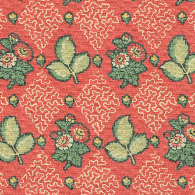 Coral red botanical fabric with green leaves and cream scrolling motifs
