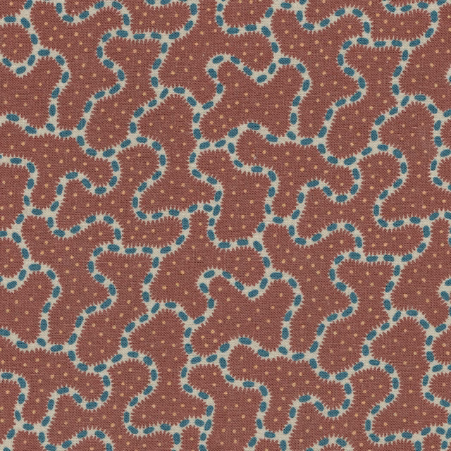Close-up of a deep red geometric fabric with turquoise outlined loops and tiny dots