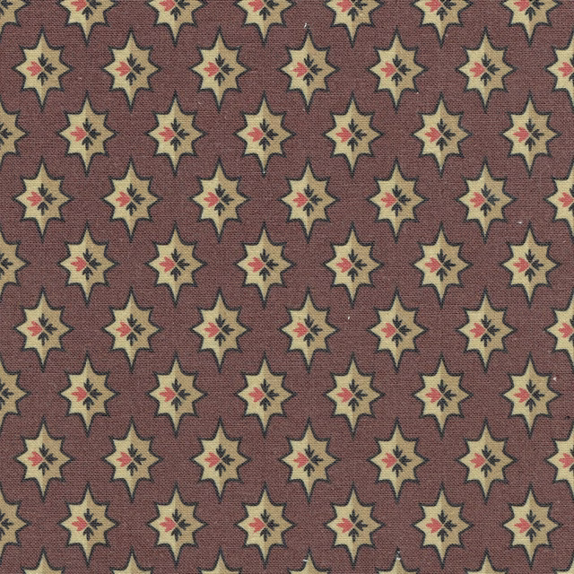 Dark red woven fabric with repeating cream star motifs and tiny red centres