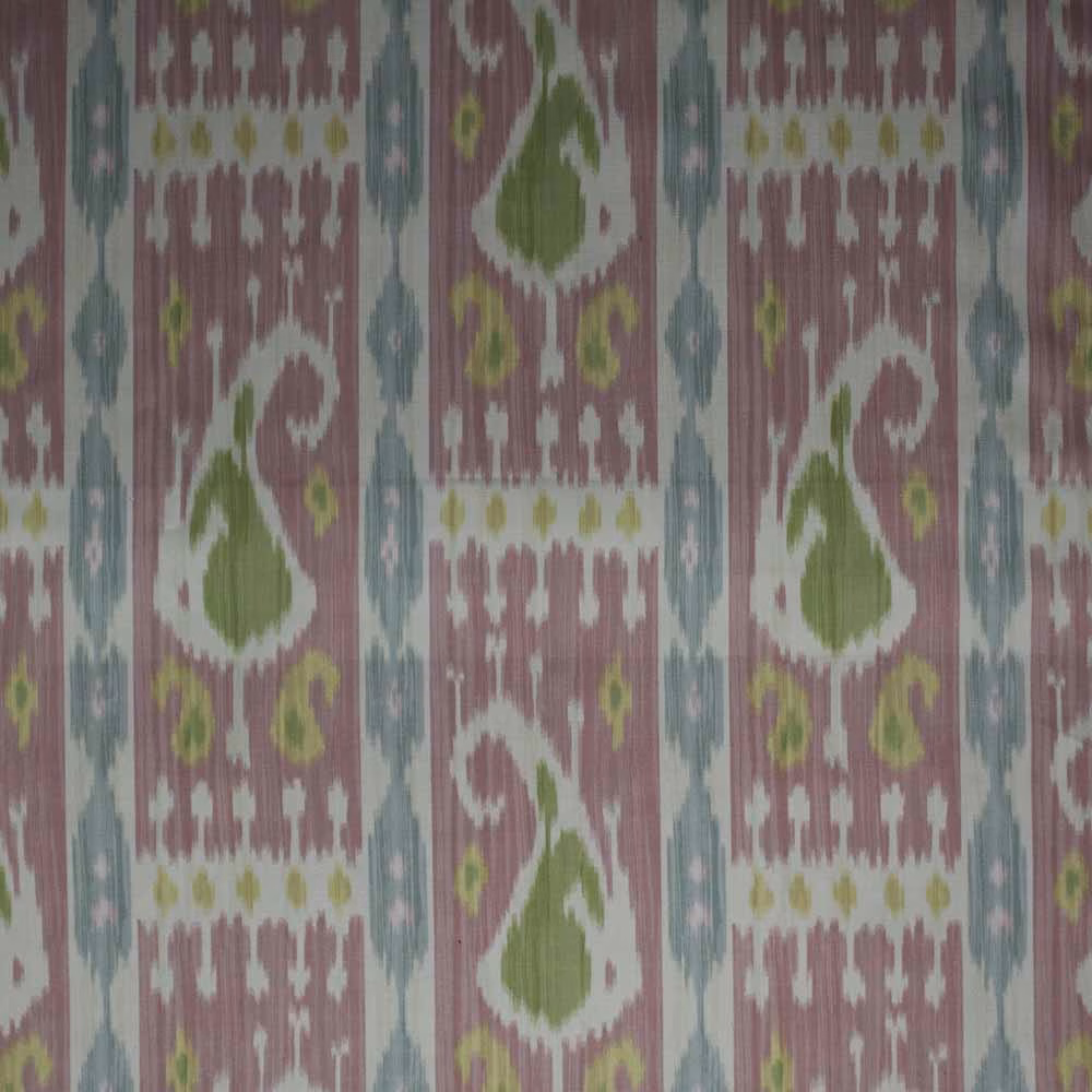 Pink ikat fabric swatch with green, blue and white geometric motifs