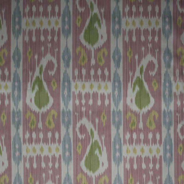 Pink ikat fabric swatch with green, blue and white geometric motifs