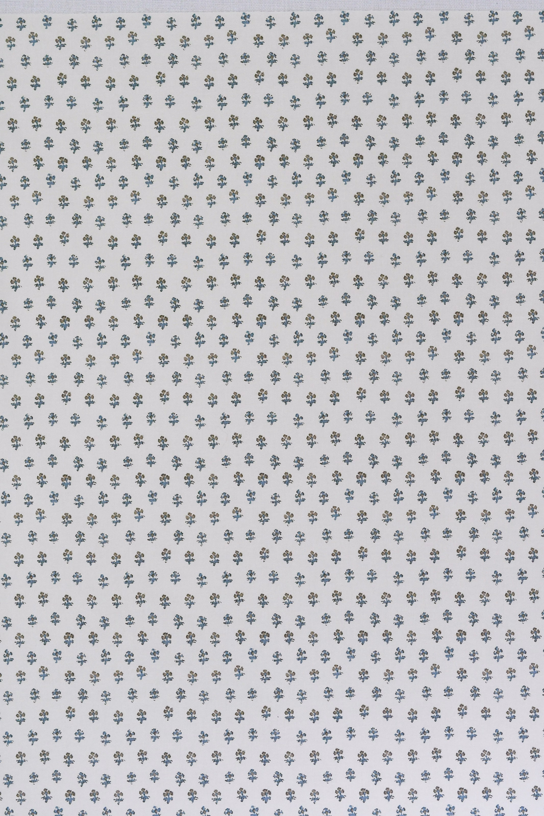 Pale fabric with tiny sage and blue-grey ditzy sprigs on a warm white ground