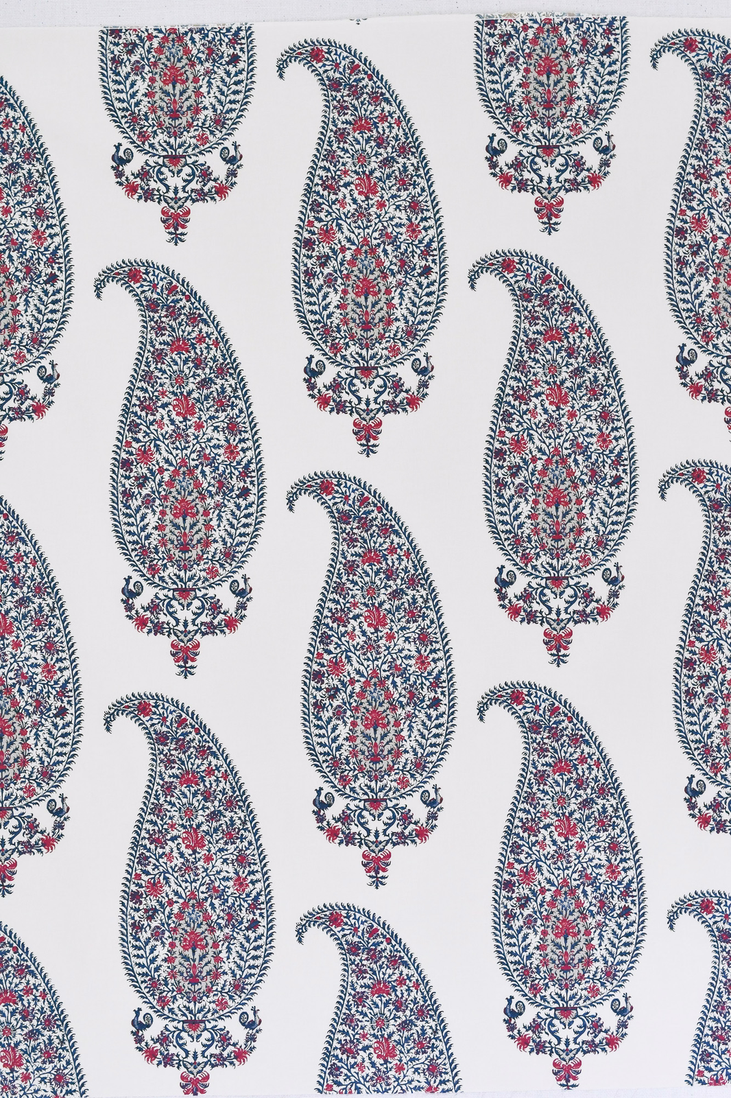 White fabric swatch with navy and red paisley teardrop motifs
