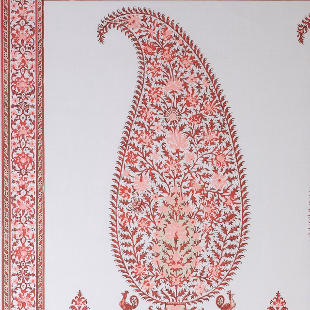 White fabric swatch with coral-red bordered paisley panel and floral damask motifs