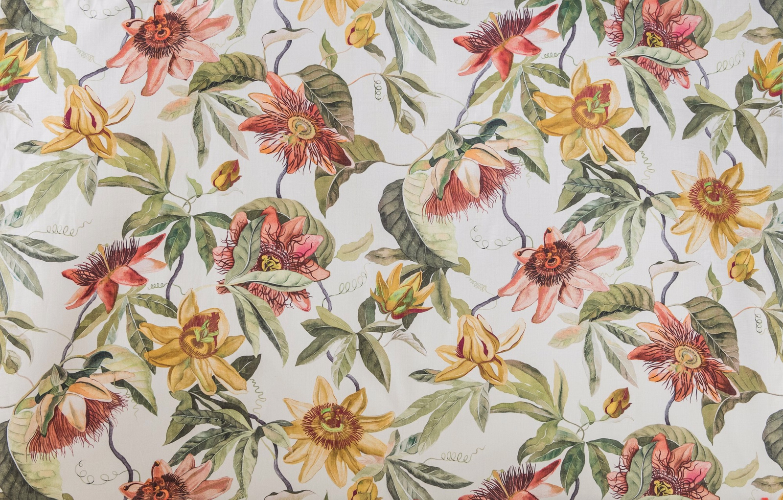 Autumn-toned passion flower print with coral, gold and green foliage on a pale ground