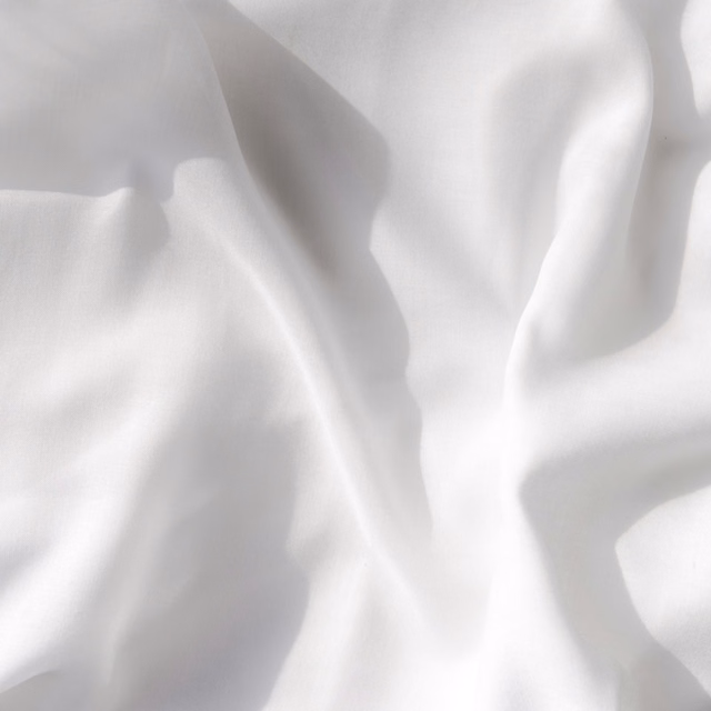 Soft white sheer fabric with gentle folds and a fine, airy weave