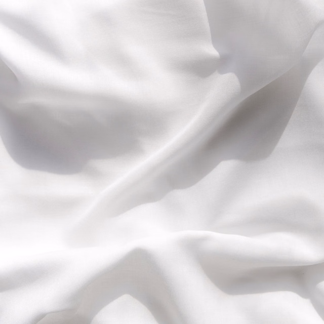 Soft white sheer fabric gathered in fluid, translucent folds