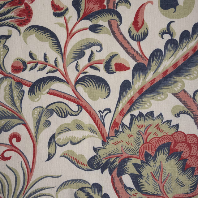 Large-scale botanical print on warm cream fabric with navy, sage and coral leaves