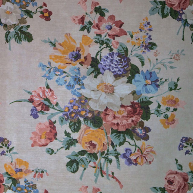 Close-up of a floral fabric with antique cream ground and multicoloured blossoms