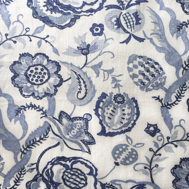 Blue and ivory floral printed fabric with scrolling stems and textured weave
