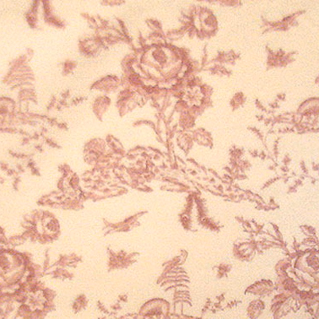 Pink toile fabric with floral sprays, birds and basket motifs on a cream ground