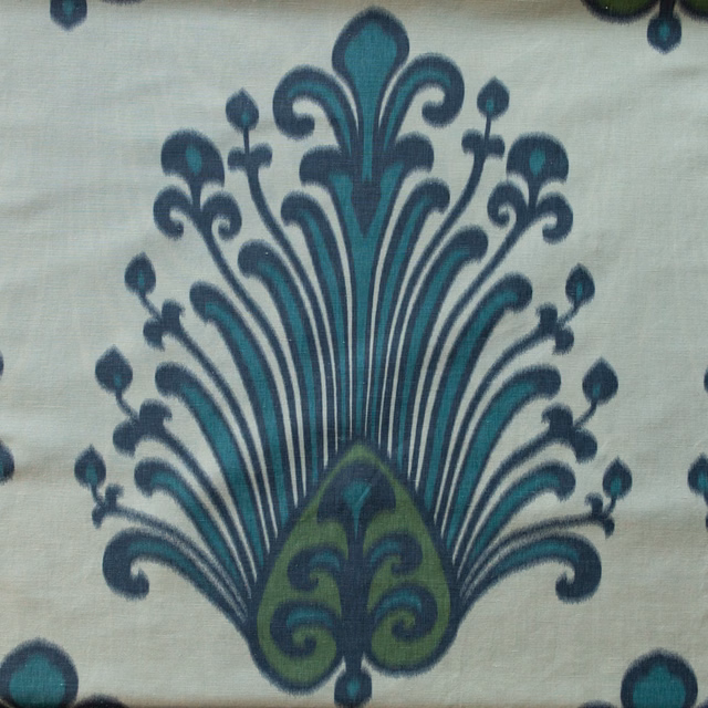 Large green damask motif on a pale sage fabric ground