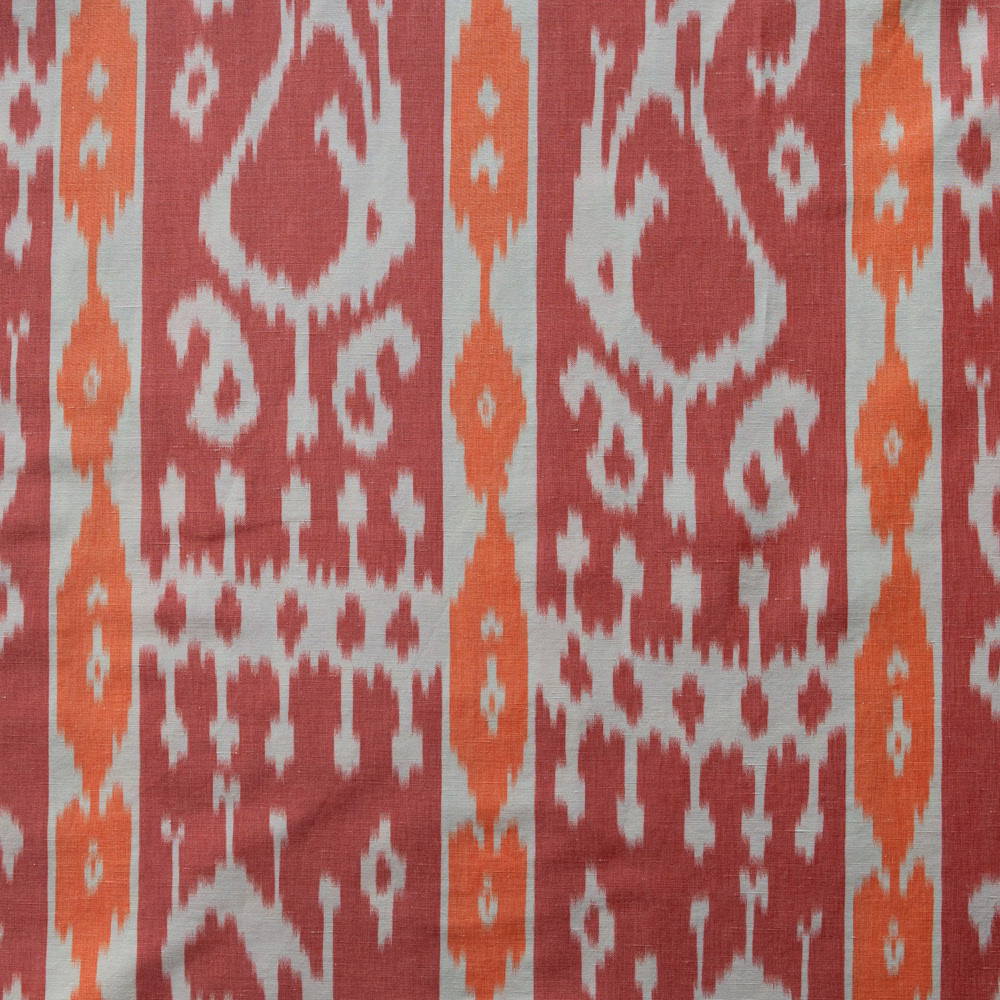 Rhubarb red and terracotta paisley-web fabric on a pale ground