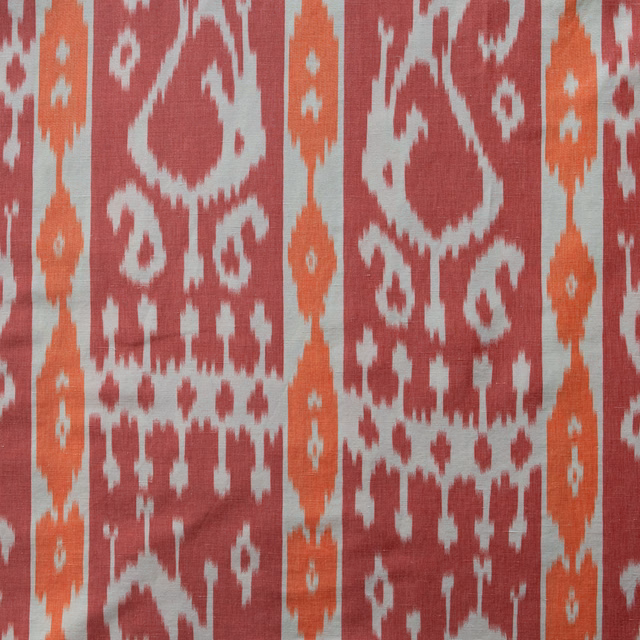 Rhubarb red and terracotta paisley-web fabric on a pale ground