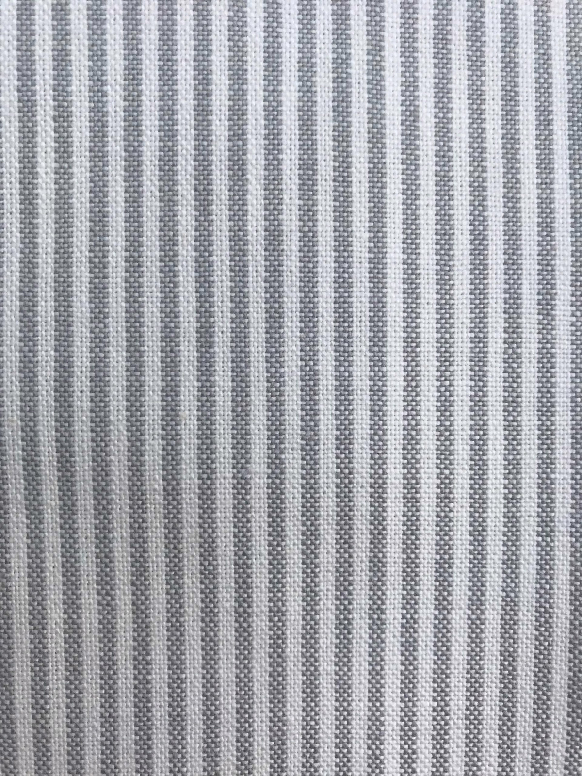 Close-up of a soft grey woven stripe fabric with fine textured bands