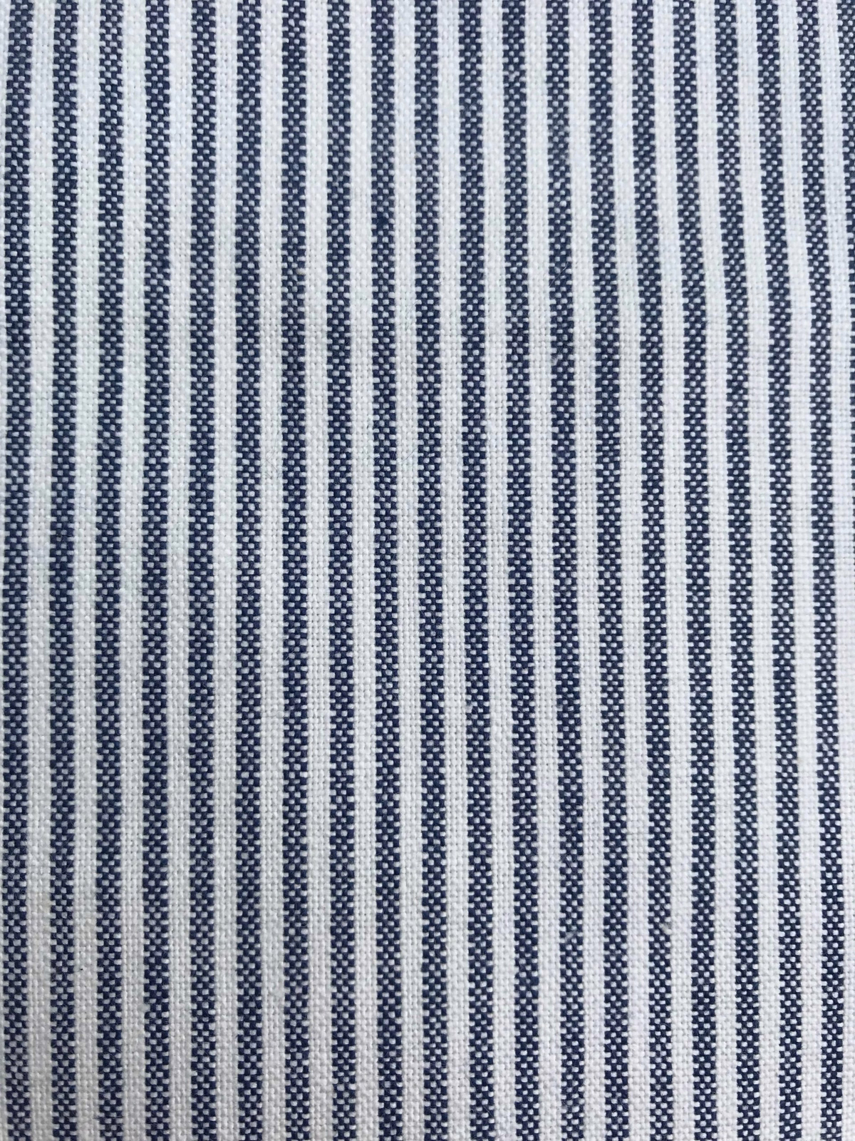 Close-up of narrow Prussian blue and off-white vertical striped woven fabric