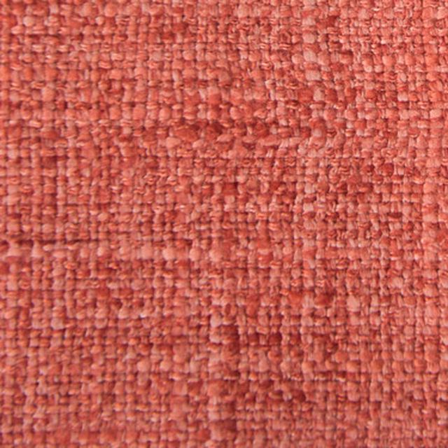 Close-up of a textured coral pink woven fabric with nubby surface