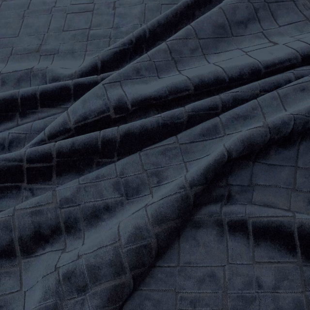 Deep indigo fabric with raised rectangular grid texture and soft sheen across folded cloth