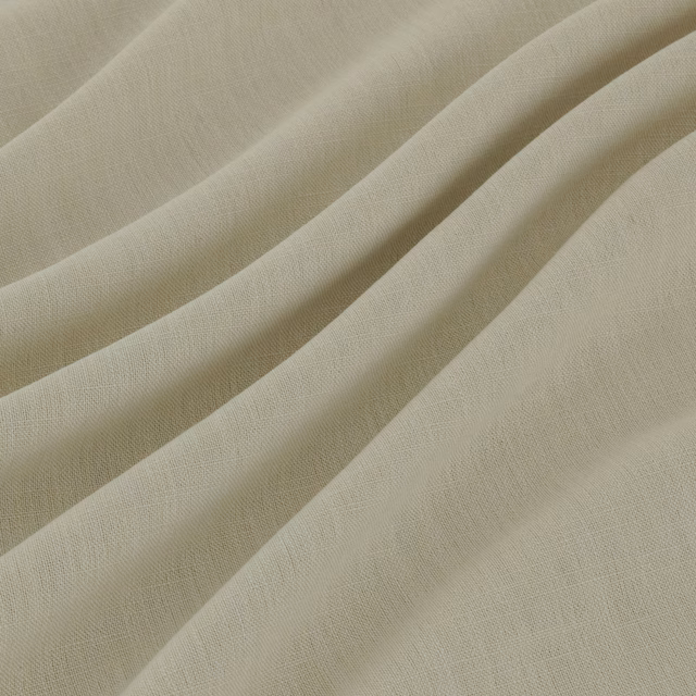 Warm ecru woven fabric with fine texture falling in soft diagonal folds