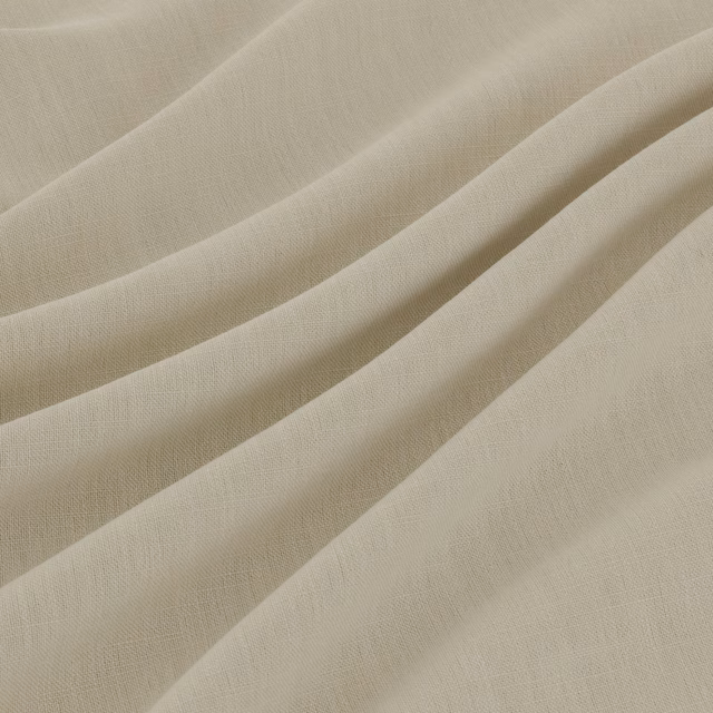 Warm ivory fine-weave fabric gathered into broad, softly lit draped folds