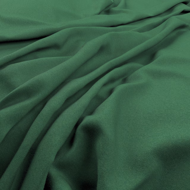 Deep forest green fabric gathered into soft, fluid folds with a matte surface