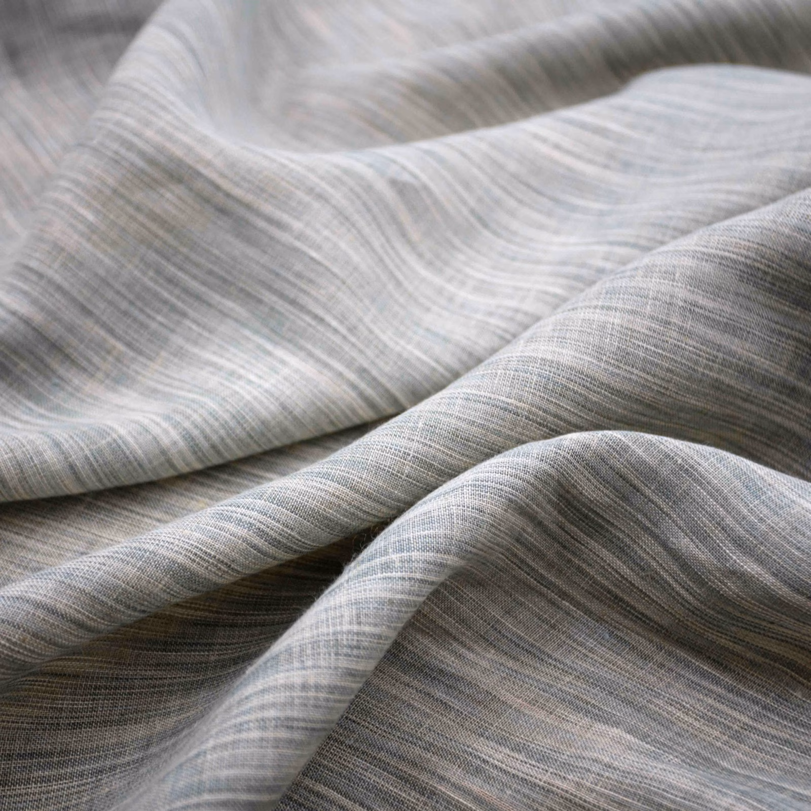 Pale eau de nil fabric with fine silvery striations folding into soft waves