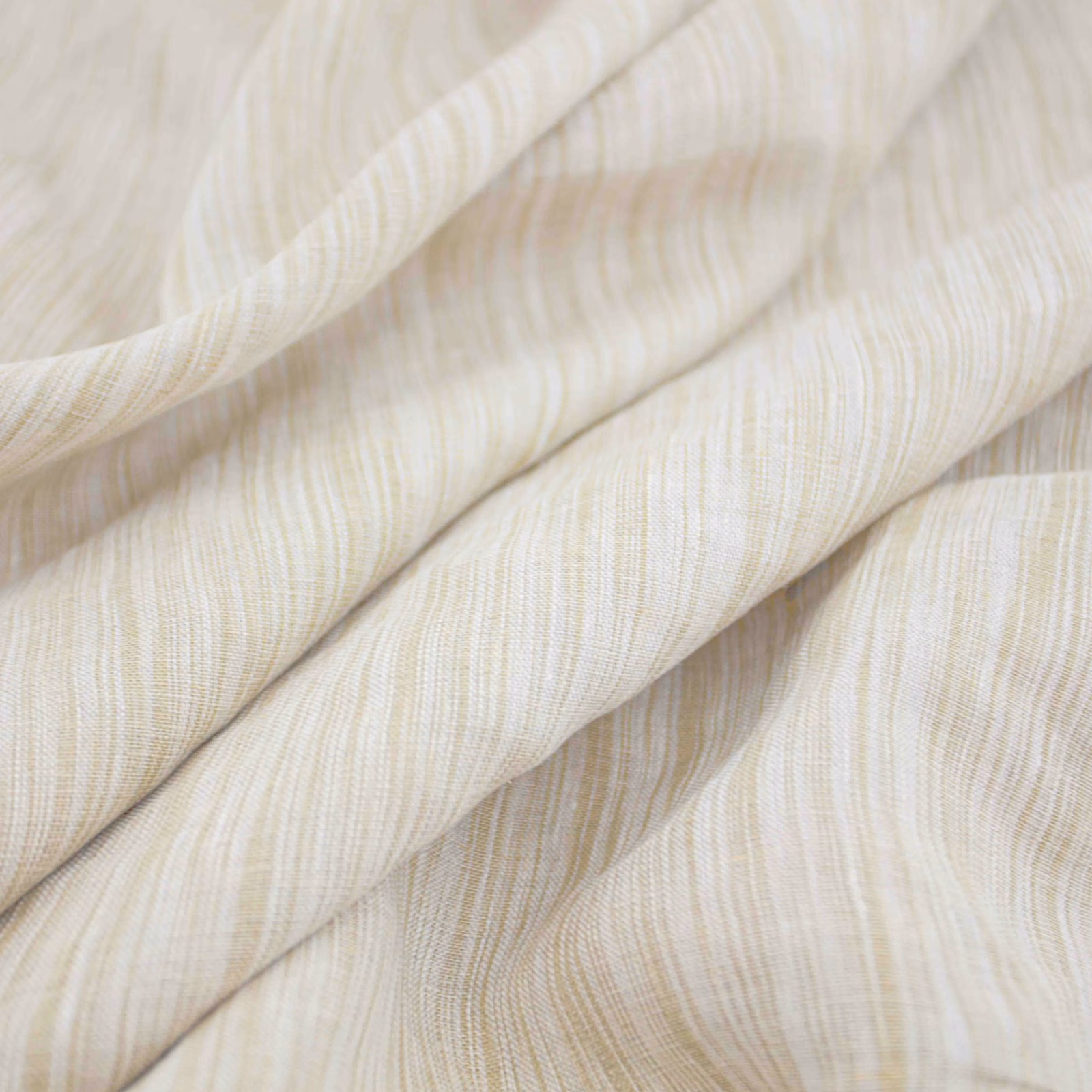 Warm ivory woven fabric with fine tan striations gathered into soft folds