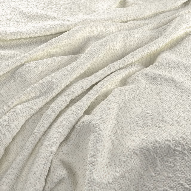 Close-up of ivory nubby fabric gathered into softly shadowed folds